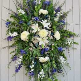 Large standing floral spray with white lilies, chrysanthemums, and blue flowers
