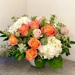 Peach roses and white hydrangeas in a low vase arrangement