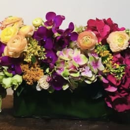 Colorful floral arrangement in a dark rectangular container