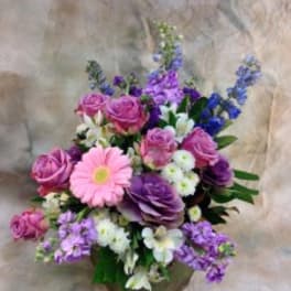 Pink and purple mixed bouquet with a pink daisy in a brown wrap
