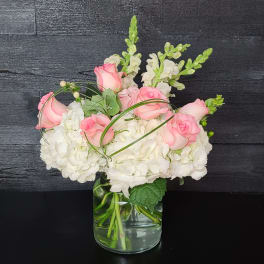Pink roses and white hydrangeas in a clear glass vase