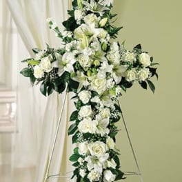 White floral cross arrangement on a stand