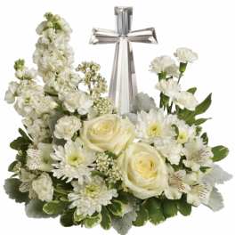 White floral arrangement with a silver cross centerpiece
