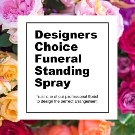 Designer’s choice funeral standing spray sign over a background of roses