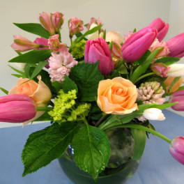 Pink tulips and peach roses in a glass vase
