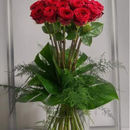Tall bouquet of red roses in a clear glass vase