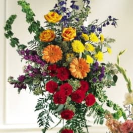 Tall standing spray with red, orange, yellow, and purple flowers