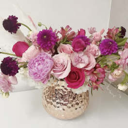 Pink and purple mixed bouquet in a textured glass vase