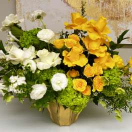 Yellow and white floral arrangement in a gold vase