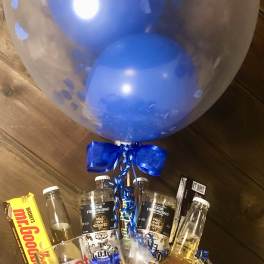 Gift basket with beer bottles, candy, and a large blue balloon