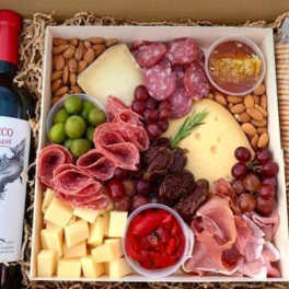 Gift basket with wine, cheese, meats, grapes, nuts, and crackers