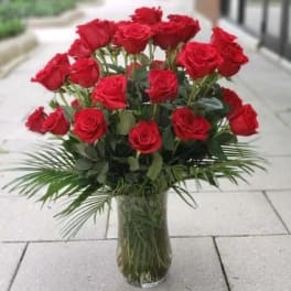 Red roses arranged in a clear glass vase