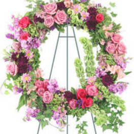 Large floral wreath on a metal easel with pink and purple flowers