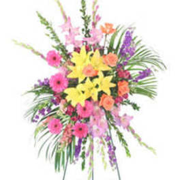 Tall mixed flower arrangement on an easel with bright pink, yellow, and purple blooms