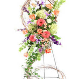Tall floral arrangement on a wire stand with pink, purple, orange, and green blooms