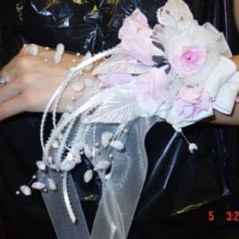 Pink and white floral wrist corsage with ribbon streamers