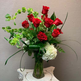 Red roses and white hydrangeas in a clear glass vase