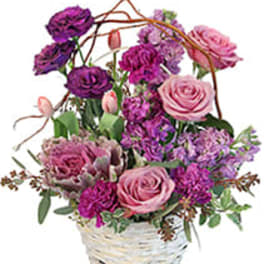 Pink and purple mixed flower arrangement in a white basket