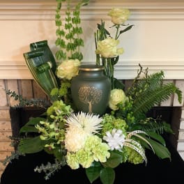 Green floral arrangement with white roses and a memorial urn