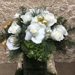White roses and green hydrangeas in a dark vase with gold ornaments
