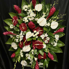 Large red, white, and pink floral standing spray on an easel