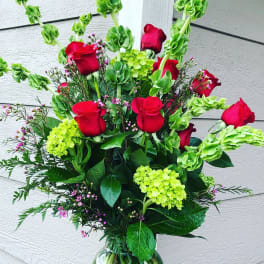 Bouquet of red roses and green hydrangeas in a glass vase