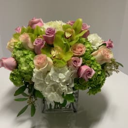 Pink roses and white hydrangeas in a clear square vase