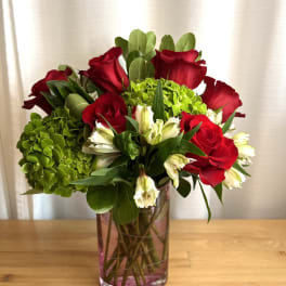 Red roses and green hydrangeas in a glass vase