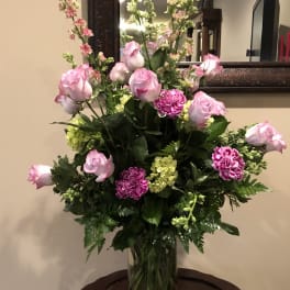 Pink roses and carnations in a clear glass vase