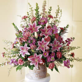 Pink lilies and mixed flowers in a woven basket