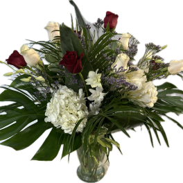 Bouquet of red and white roses with white hydrangeas in a glass vase
