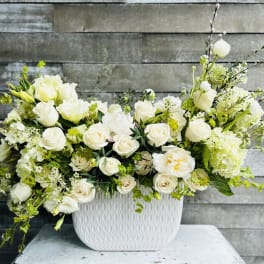 White roses and mixed white flowers in a textured white vase