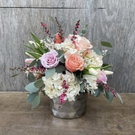 Bouquet of pastel roses and white hydrangeas in a gray vase