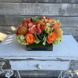 Bright mixed bouquet in a square glass vase