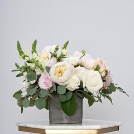 Blush and white floral arrangement in a gray vase