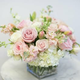Blush pink and white bouquet in a square glass vase