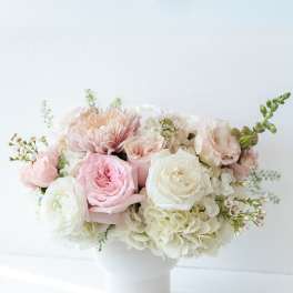 Pink and white flower arrangement in a white vase