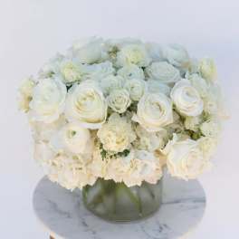 White rose and carnation arrangement in a glass vase
