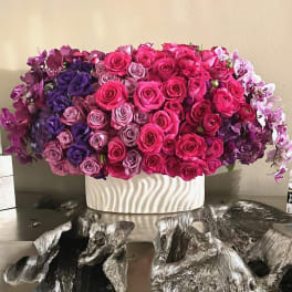 Large arrangement of pink and purple roses in a white vase