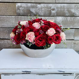 Red and pink roses arranged in a silver bowl
