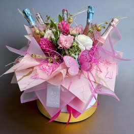 Pink and white flower bouquet with champagne bottles and a butterfly decoration