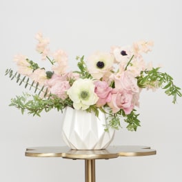 Pink and white floral arrangement in a white vase