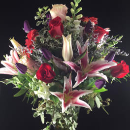 Mixed bouquet of red roses and pink lilies in a glass vase