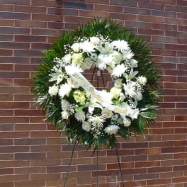 White funeral wreath on a stand with a ribbon