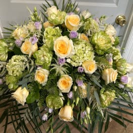 Large floral spray with cream roses, green blooms, and lavender accents