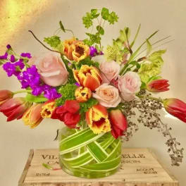 Mixed bouquet of tulips and roses in a glass vase