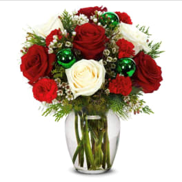Red and white roses in a clear glass vase with green ornaments