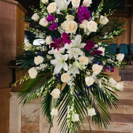 Large standing floral spray with white lilies, roses, and purple orchids