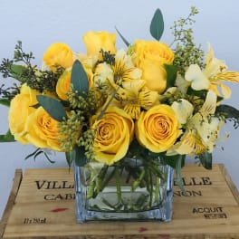 Yellow roses and alstroemeria in a clear glass vase