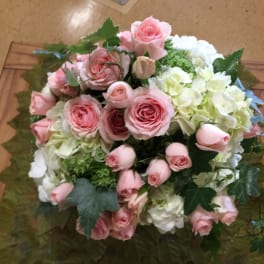 Pink roses and white hydrangeas arranged in a round bouquet